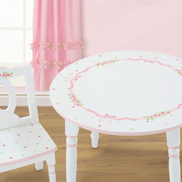 a white table and two chairs in a room with pink walls, wood floors and wooden flooring