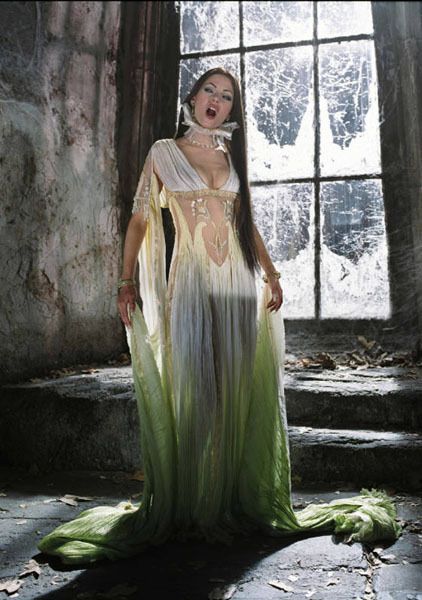 a woman in a long dress standing next to a window with her mouth wide open