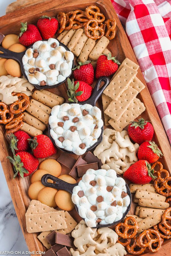 a platter filled with pretzels, strawberries and other snacks