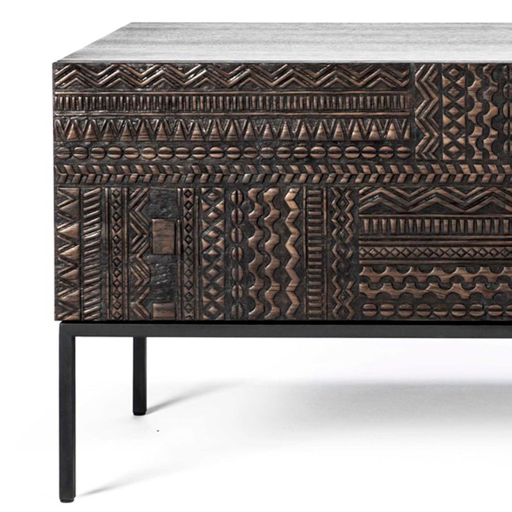 a wooden cabinet with an intricate design on the front and bottom, along with black legs