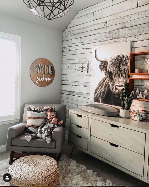 the room is decorated in white and has a cow head on the wall above the dresser