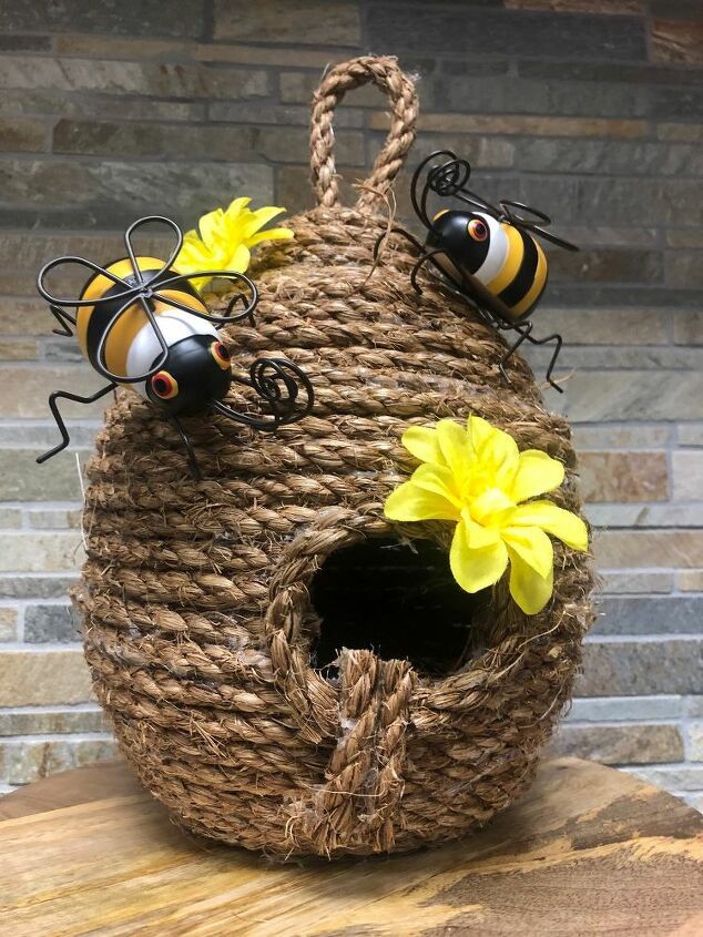 two bees sitting on top of a basket with yellow flowers in the bottom and black eyes