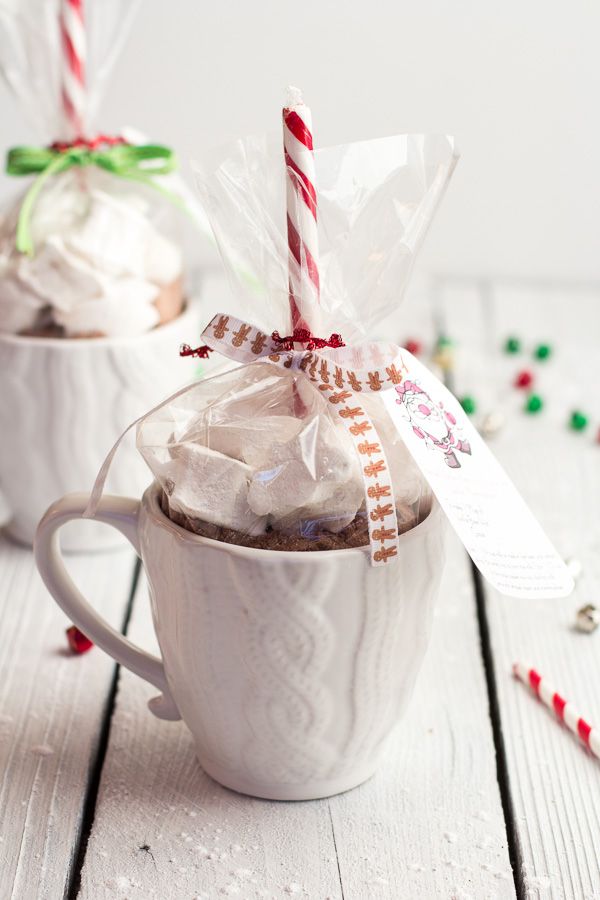 two cups filled with hot chocolate and candy canes