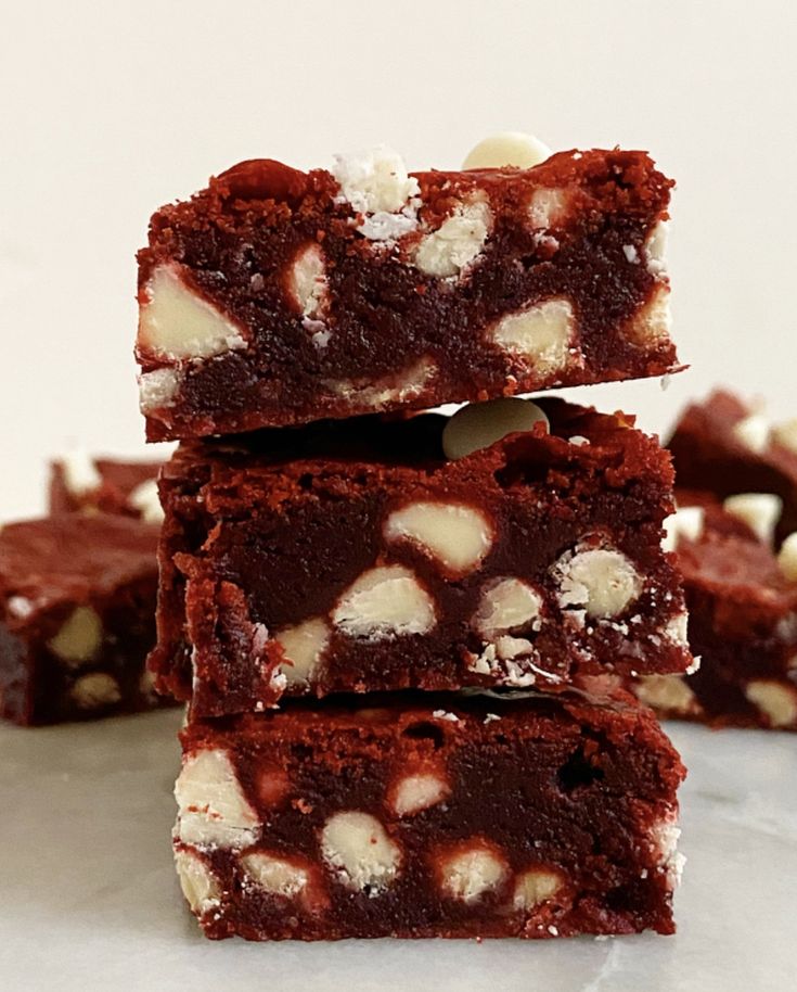 some brownies are stacked on top of each other and have white chocolate in them