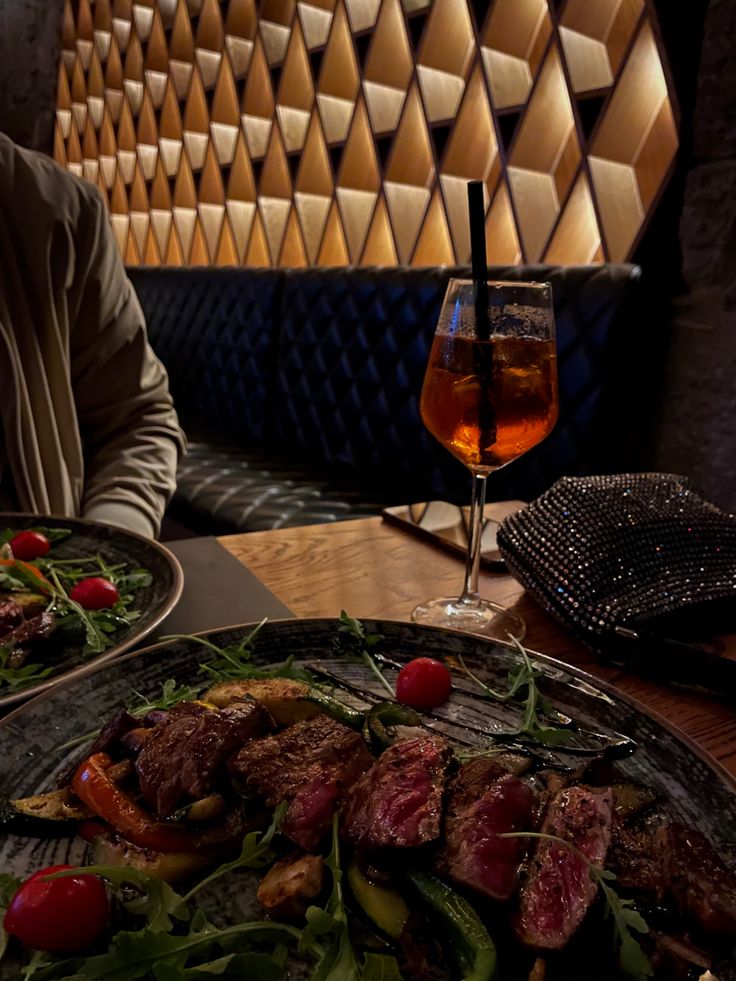 a man sitting at a table with plates of food and drinks in front of him