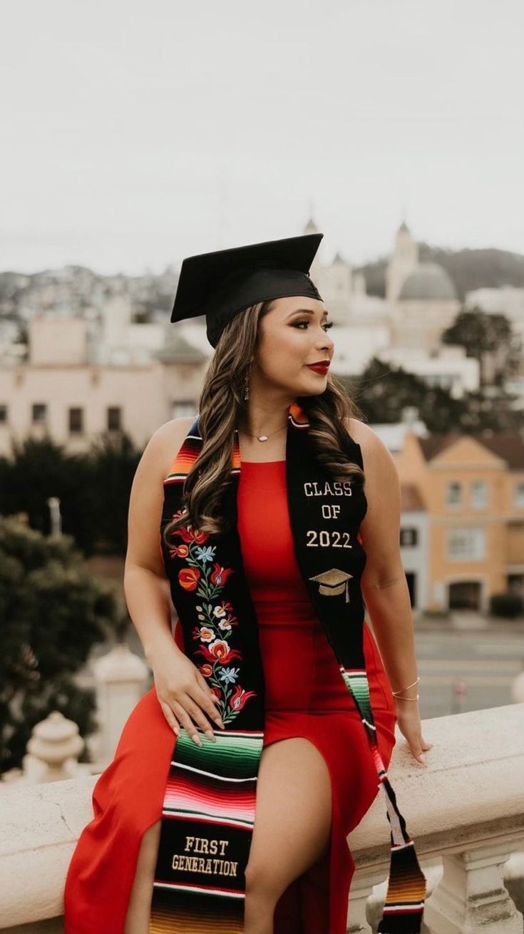 a woman in a graduation gown sitting on a ledge