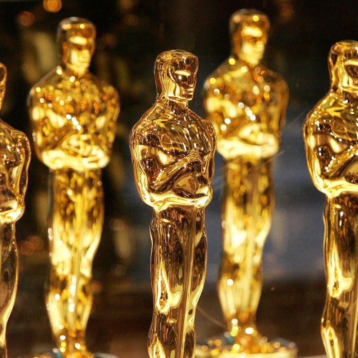 many oscar statues are lined up in rows