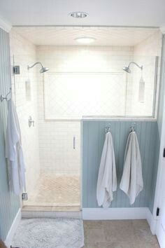 a bathroom with two towels hanging on the wall and one towel rack in the shower