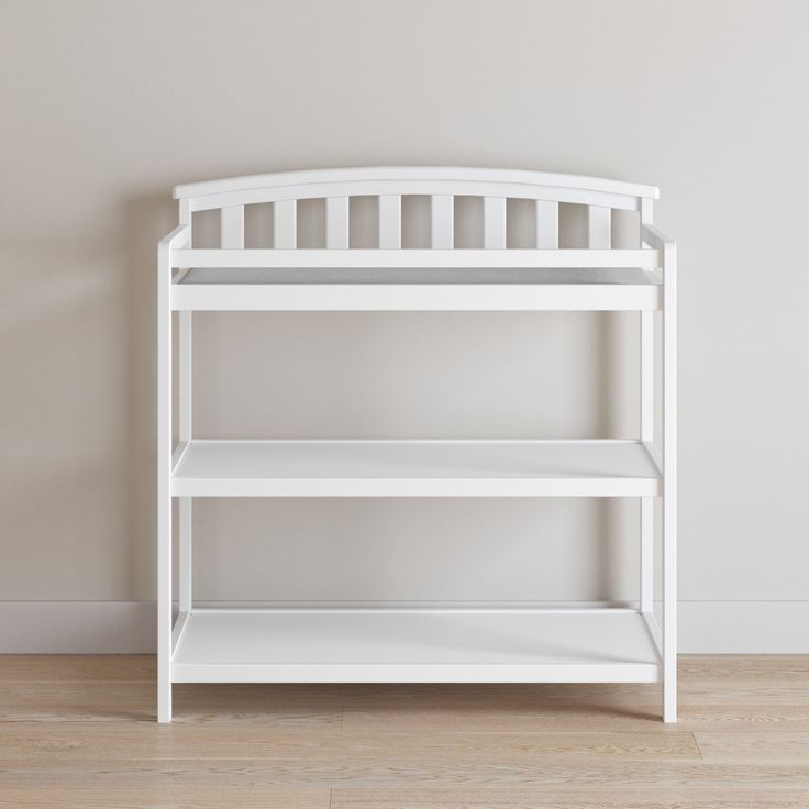 a white book shelf against a wall in an empty room