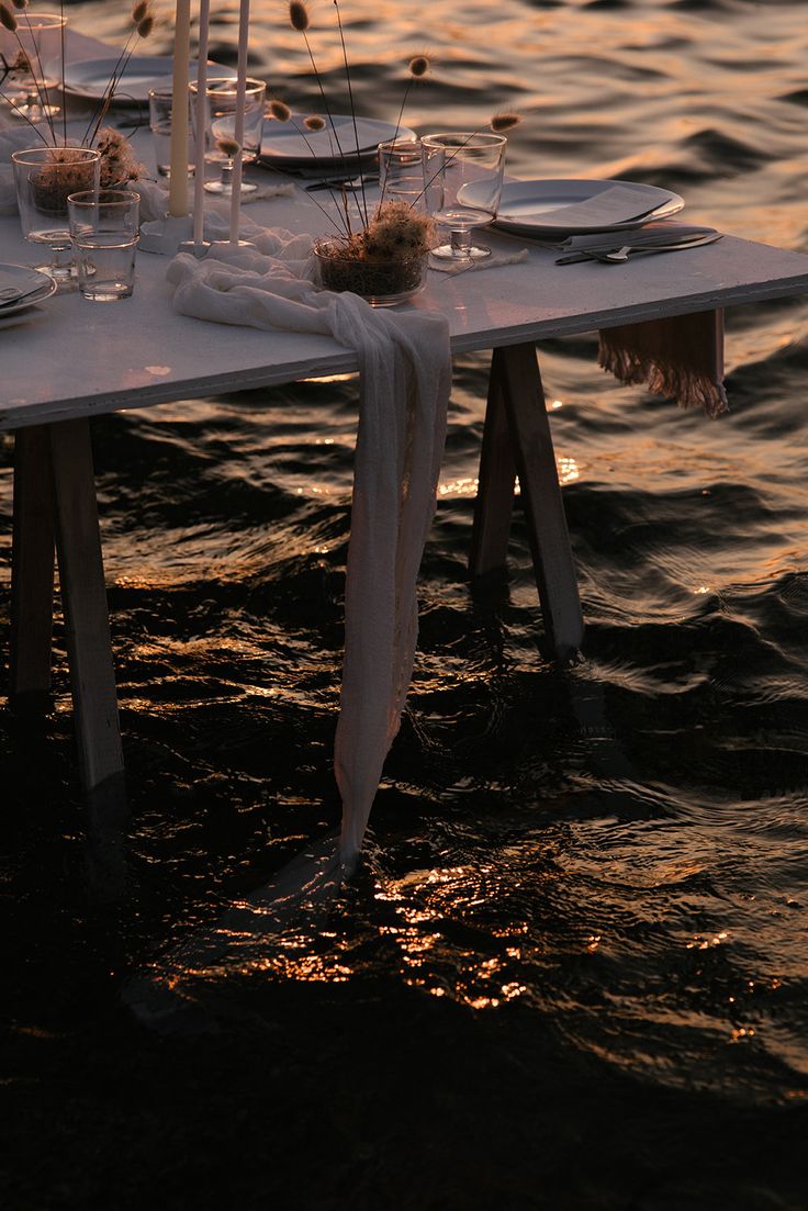 the table is set for dinner on the water