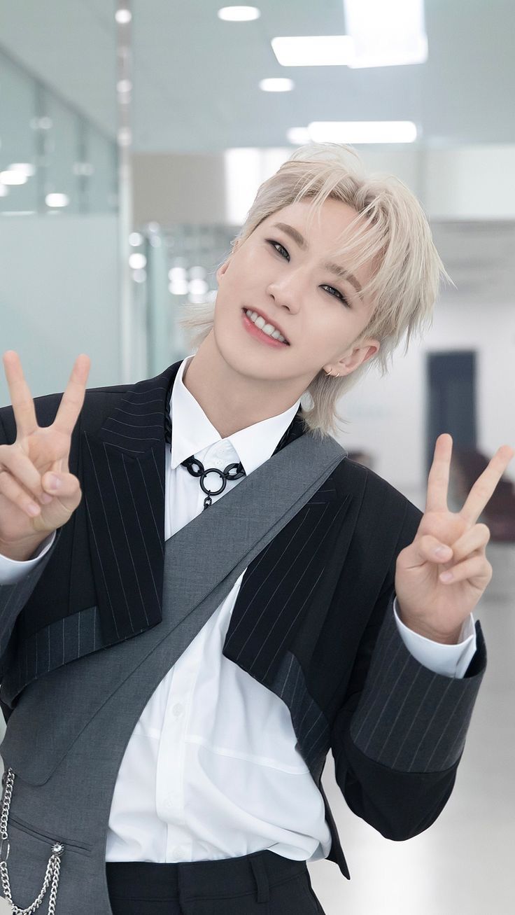 a person in a suit and tie making the peace sign