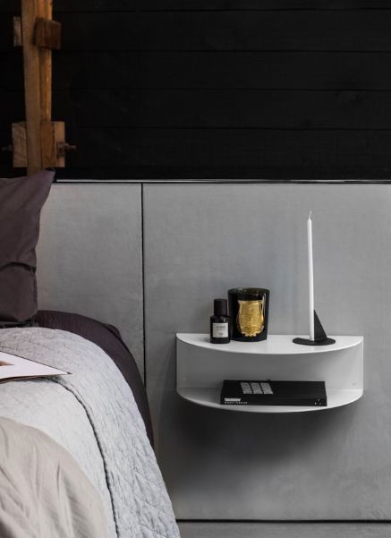 a bed with a night stand next to it on top of the headboard and pillows