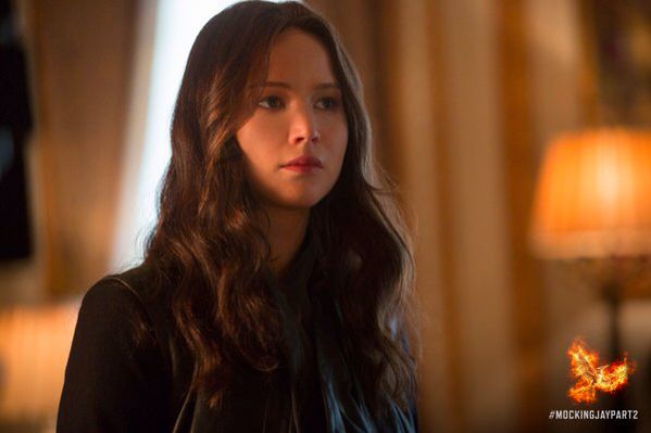 a woman with long brown hair is looking at the camera while wearing a black jacket