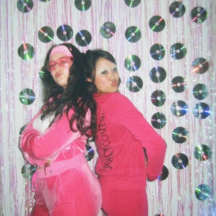 two women in pink pajamas standing next to each other with bubbles on the wall behind them