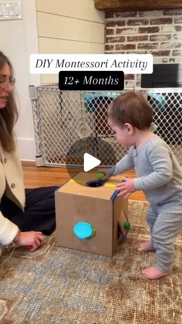 a woman is playing with a baby in a box on the floor while another child looks at it