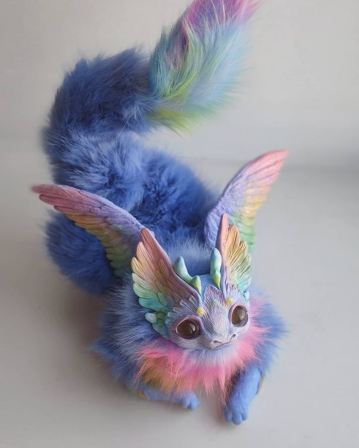 a small stuffed animal with multicolored feathers on it's back