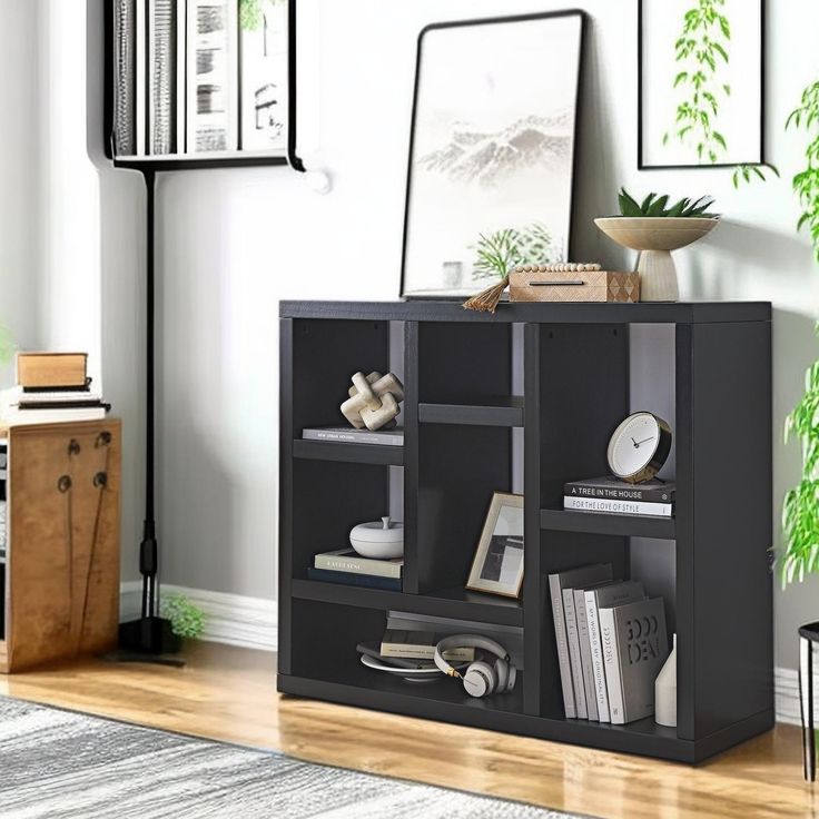 a living room with a book shelf filled with lots of books and other things on top of it