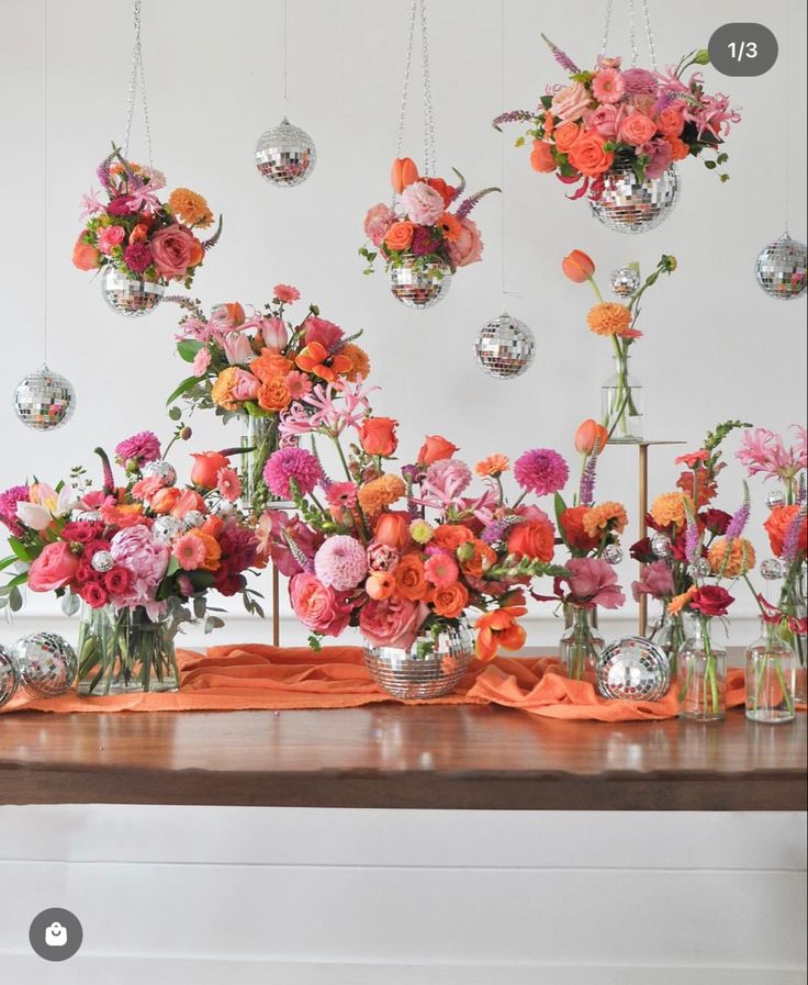 a table topped with lots of vases filled with colorful flowers on top of it