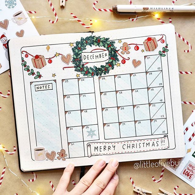 someone holding up a christmas calendar on top of a table with candy canes around it