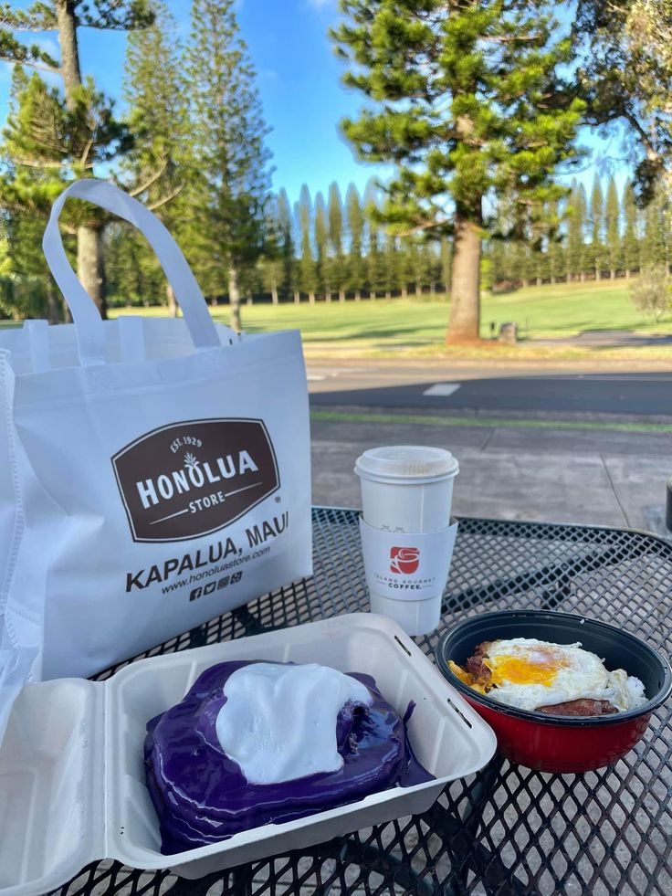 a bag and some food sitting on top of a table near a cup of coffee