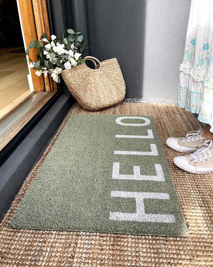 a door mat with the word hello written on it next to a pair of shoes