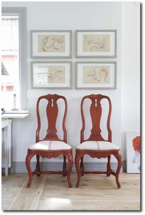 two red chairs sitting next to each other on top of a hard wood floored floor