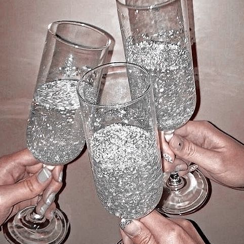 three people holding up wine glasses with bubbles in them