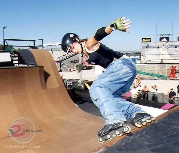 a man riding a skateboard up the side of a ramp at a skate park