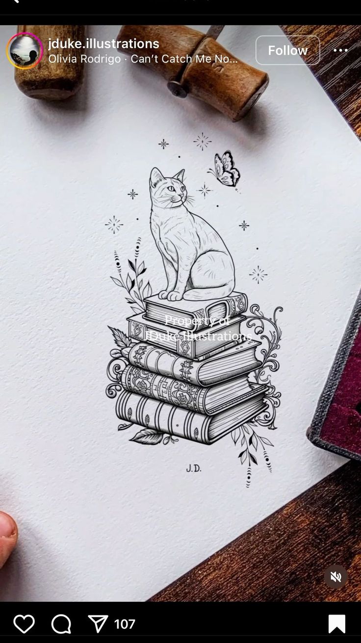 a drawing of a cat sitting on top of a stack of books next to a rubber stamp