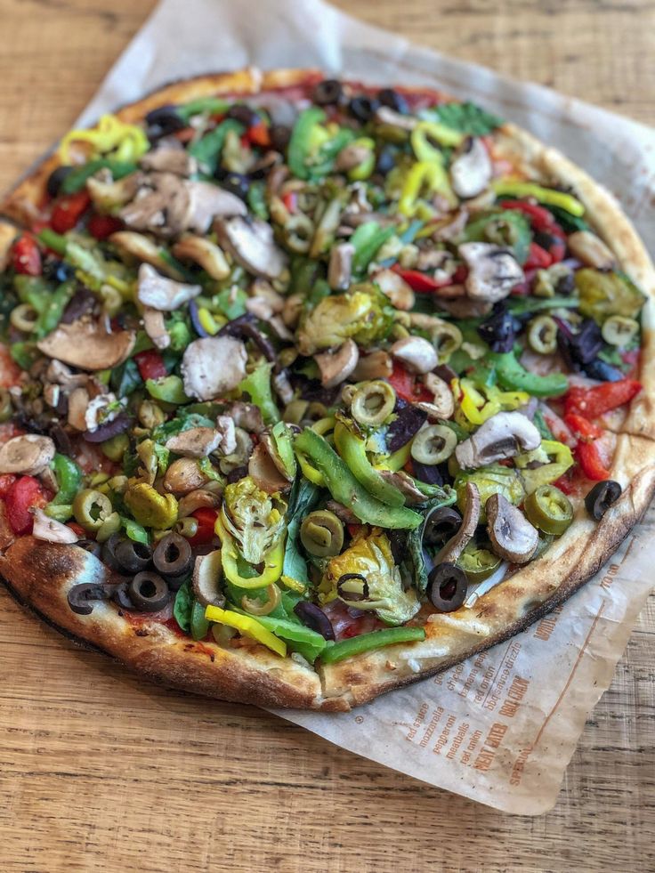 a pizza sitting on top of a table covered in lots of veggie toppings