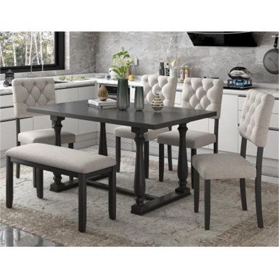 a dining room table with chairs and a bench in front of the kitchen countertop