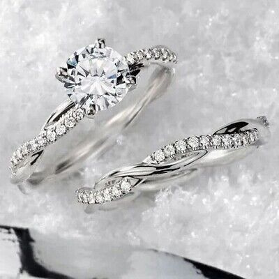 two white gold wedding rings with diamonds in them on snow covered ground next to each other