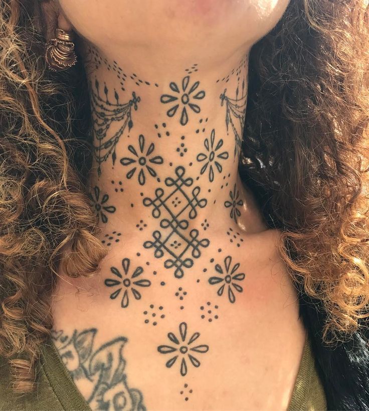 a woman with tattoos on her neck and chest