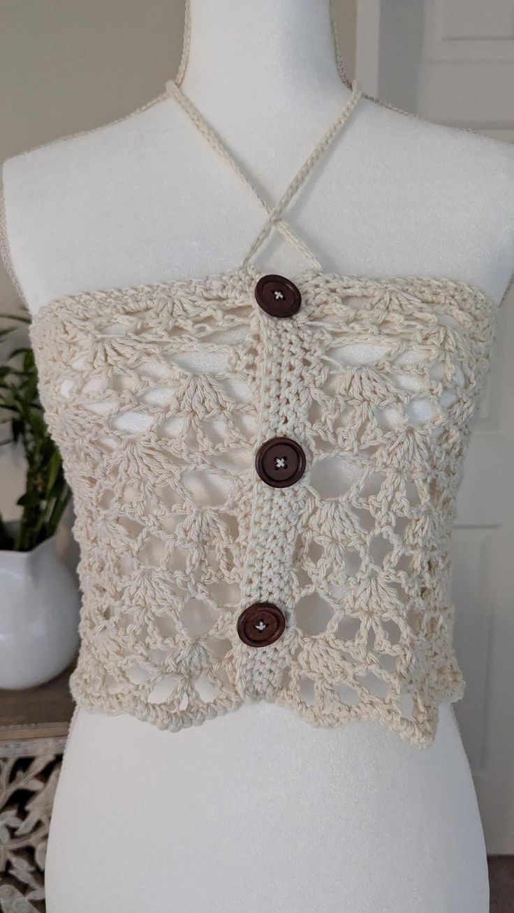 a white mannequin with buttons on it's chest and lace trims