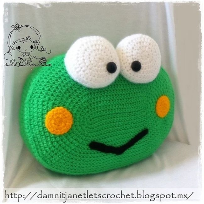 a crocheted green frog purse with googly eyes on it's face