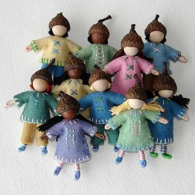 a group of dolls sitting next to each other on a white surface with one doll in the middle