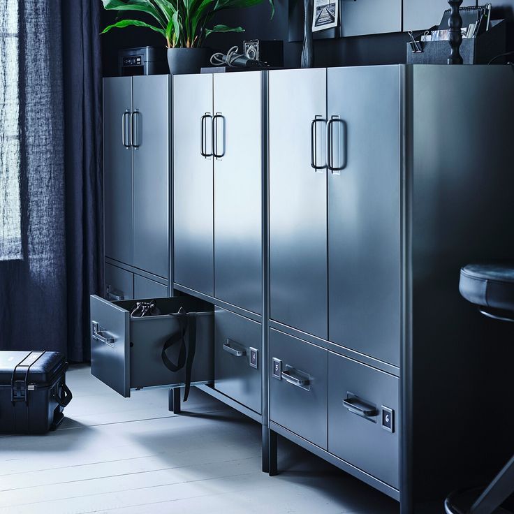 a large metal cabinet sitting next to a window in a room with white flooring