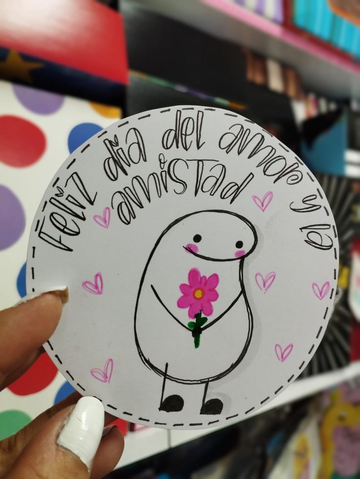 a person holding up a sticker with flowers on it