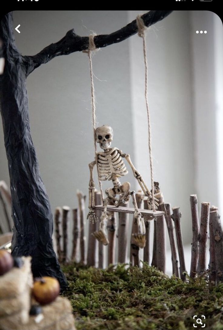 a fake skeleton is sitting on a swing