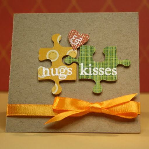 a card with two pieces of puzzle on it and the words hugs kisses written on them