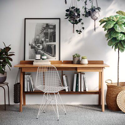 a room with two plants on the wall next to a table and chairs in front of it