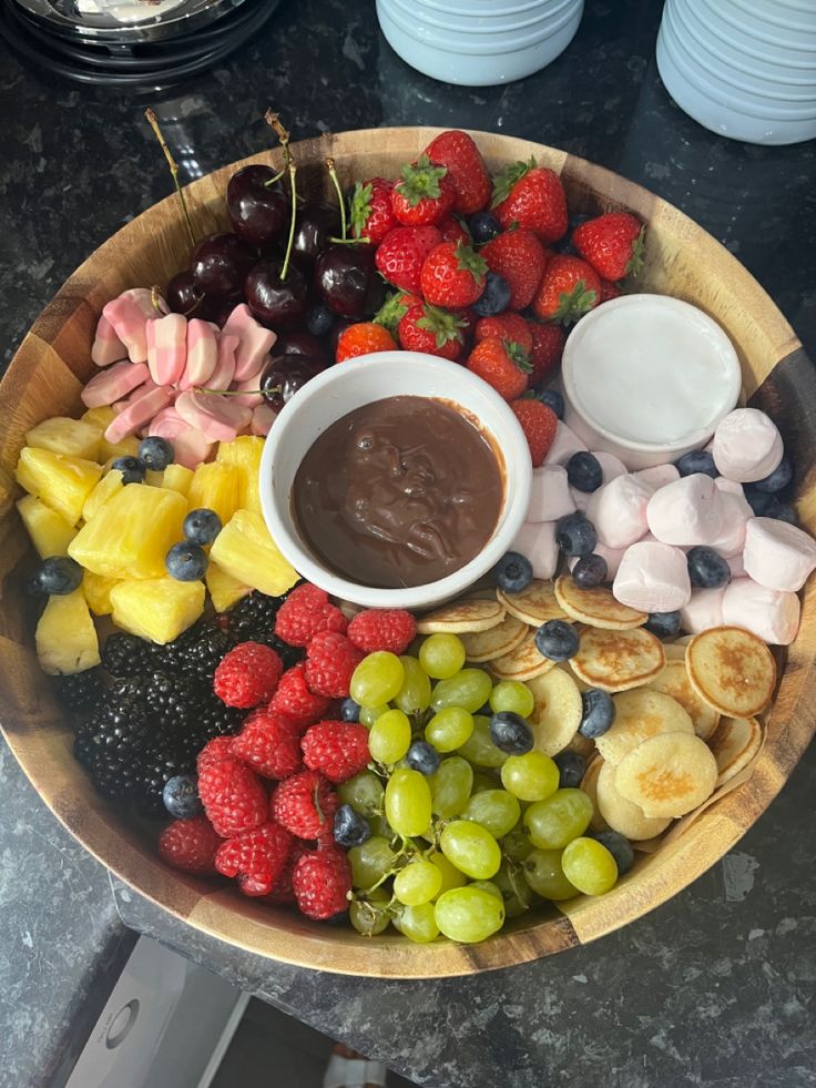 a platter filled with fruit and chocolate dip