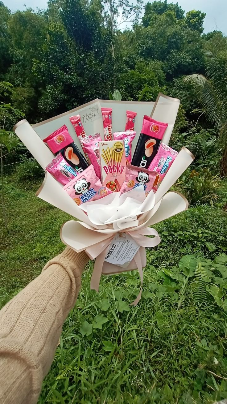 a person is holding a bouquet with various items in it, including lipstick and toothpaste