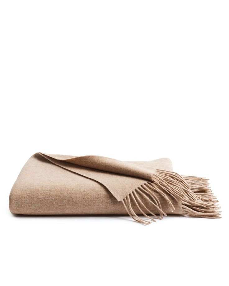 The Petite Plume Cashmere Fringe Throw in Beige, with its luxurious softness and elegant fringe edges, is folded neatly against a white backdrop—an ideal addition to your home decor. Brown Throw Blanket, Beige Throws, Fringe Throw, Wool Throw Blanket, Gift Sets For Her, Matching Baby, Wool Throw, Stocking Stuffer Gifts, Matching Gifts