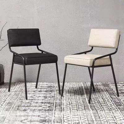 two black and white chairs sitting next to each other on a rug in front of a gray wall