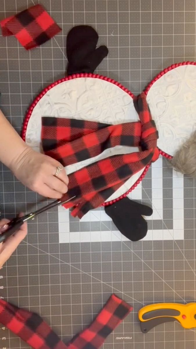 someone is cutting out some fabric to make mickey mouse ears with scissors and other items