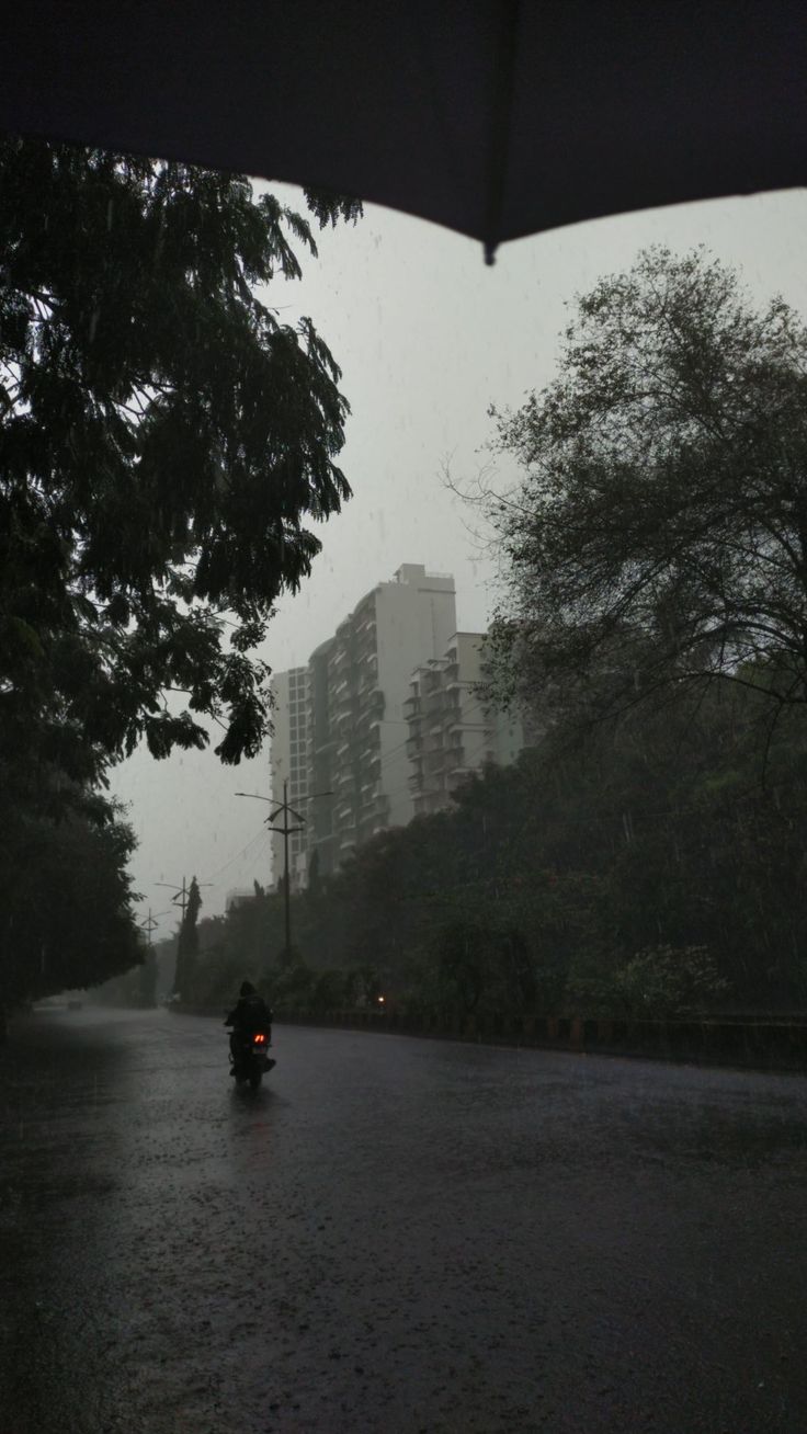 a person riding a motorcycle down a rain soaked street