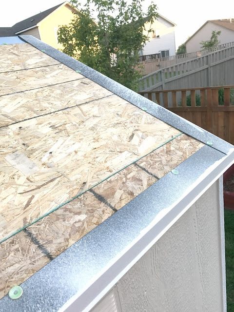 the roof of a house is covered with wood shingles and plastic sheeting as it sits in front of a backyard fence