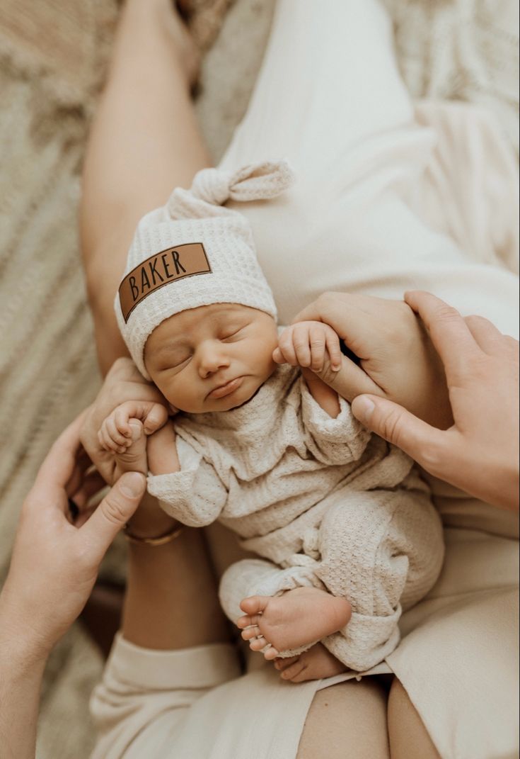 a person holding a baby wearing a baker hat