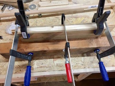 several different tools are hanging from the ceiling in a room that is being built with wooden planks